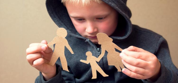 Small boy holds broken paper cutout family