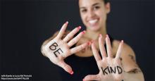 Smiling teacher has be kind written on palms of hand